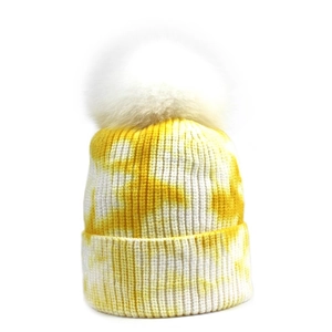 Bonnet en maille tie-dye jaune et blanc avec pompon en fausse fourrure pour l'hiver