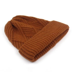Detailed close-up of knitted diamond pattern and thick rolled cuff on a brown beanie
