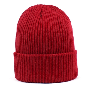 Gros plan sur la texture en maille côtelée rouge foncé d'un bonnet d'hiver épais