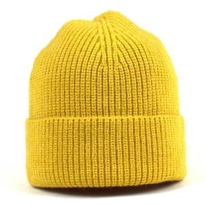 Detail shot of bright yellow knit beanie featuring thick vertical ribbed texture and wide cuff