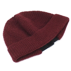 Deep red knit beanie with waffle texture, ribbed cuff, and functional buckle detail
