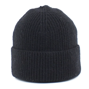 Close-up detail of black ribbed knit beanie showing thick texture and folded cuff design