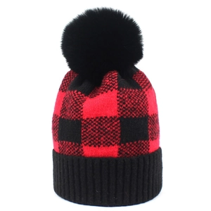 Winter plaid knitted beanie hat with a fluffy black pom-pom and warm ribbed cuff