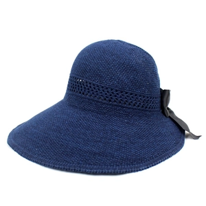 Detail of the navy wide brim sun hat featuring a knit texture and black silk bow accent