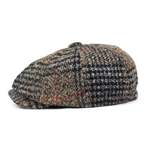 Detail of tweed newsboy cap showing brown and orange plaid texture and top button