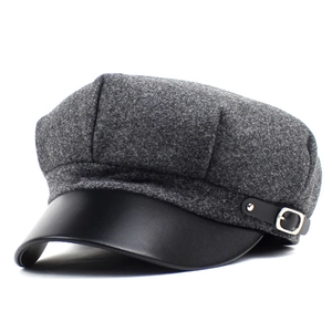 Detail of grey wool octagonal newsboy cap with black leather brim and metal buckle