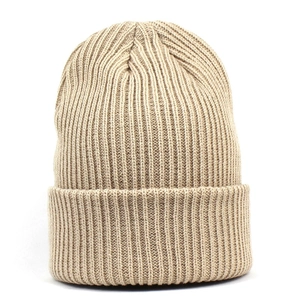 Gros plan du bonnet en tricot kaki montrant la texture des coutures côtelées verticales