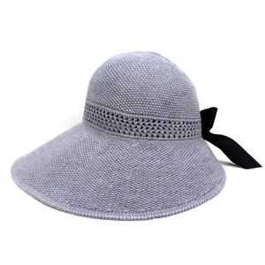 Detail of grey knitted sun hat showing breathable mesh and black silk bow decoration
