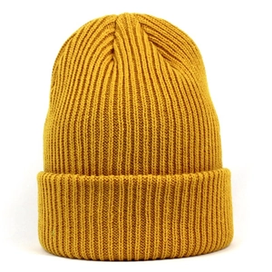 Gros plan détaillé d'un bonnet en maille jaune gingembre avec texture côtelée et revers fixé