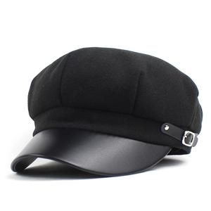 Detail of wool octagonal cap featuring a black leather brim and silver metal buckle