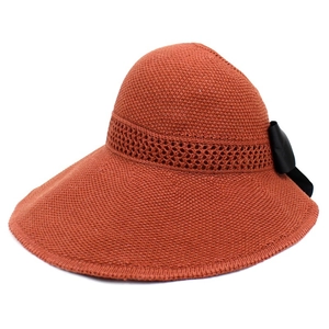 Detailed knit texture and black satin bow on the brim of a wide-brimmed sun hat