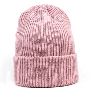 Détail de la texture en maille côtelée rose et du large revers d'un bonnet d'hiver chaud