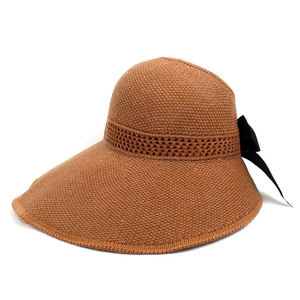Detail of woven sun hat with wide brim featuring a large black silk bow on the back