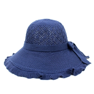 Detail of navy blue knitted sun hat featuring hollow diamond pattern and side bow