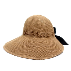 Detail of wide brim straw hat with a large black decorative ribbon bow on the back