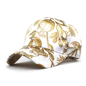 Detail view of cotton baseball cap with vintage golden pomegranate floral print