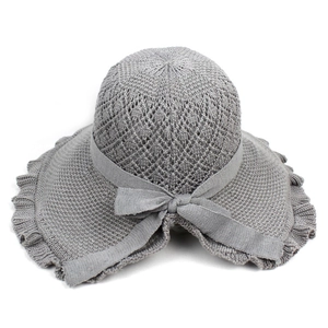 Grey knitted summer sun hat with elegant lace brim and knit bow on white background