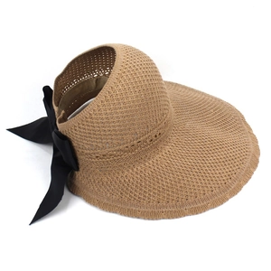 Dettaglio cappello di paglia kaki con elegante fiocco in raso nero e tesa larga