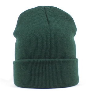 Close-up detail of dark green ribbed knit beanie showing thick texture and stitching