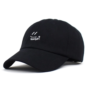 Close-up of white smile text and icon embroidery on black cotton baseball cap