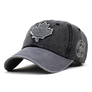 Close-up of vintage washed grey cotton baseball cap with maple leaf embroidery and Canada badge