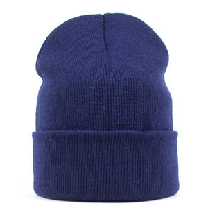 Detail of navy blue knitted beanie featuring fine ribbed texture and folded cuff for warmth