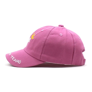 Detail view of pink cotton baseball cap with yellow crown embroidery and TEAMO lettering