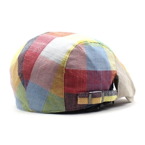 Close-up of adjustable metal buckle and plaid fabric texture on a vintage beret