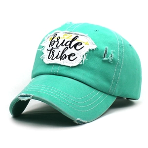 Detail of mint green washed cotton baseball cap with distressed brim and bride tribe patch