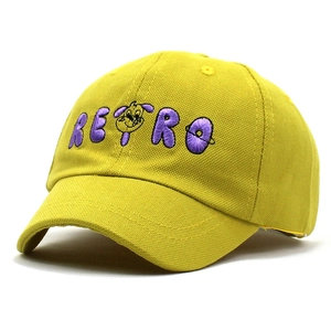 Détail d'une casquette en coton jaune moutarde avec broderie RETRO violette