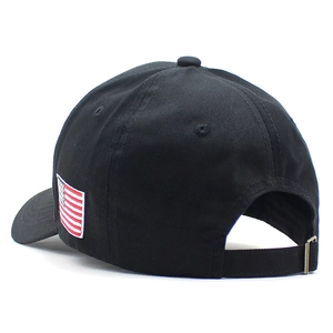 Detail view of black baseball cap with American flag embroidery and adjustable metal buckle