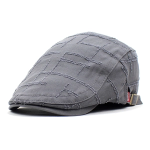 Detail of grey vintage cotton beret featuring raw edge quilted checks and metal buckle