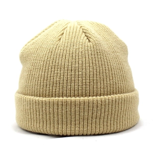 Detailed close-up of khaki ribbed knit texture and wide folded cuff on a warm winter beanie