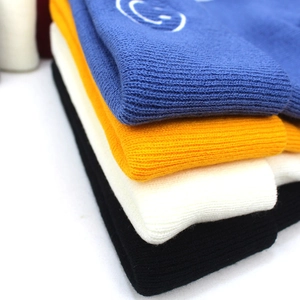 Dettaglio di berretti in maglia a coste in quattro colori con ricamo smiley
