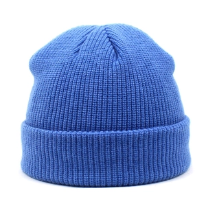 Close-up of bright blue knitted beanie showing thick ribbed texture and folded cuff detail