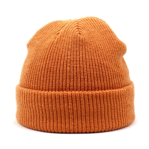Close-up of bright orange ribbed knit beanie showing high-quality texture and cuffed design