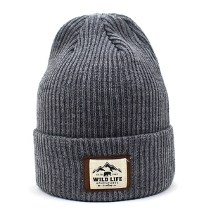 Detailed view of dark grey ribbed knit beanie featuring a wild life mountain patch