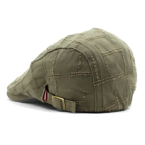 Detail view of olive green canvas flat cap featuring vintage frayed edges and cross stitching