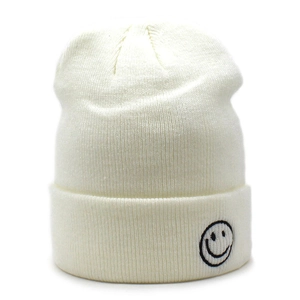 Dettaglio del berretto in maglia bianco crema con trama a costine e smiley ricamato