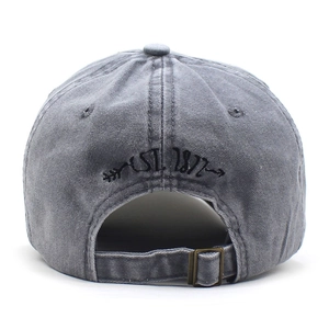 Detail view of washed grey cotton baseball cap featuring EST. 1977 embroidery and metal buckle