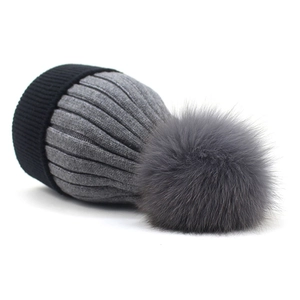 Detailed view of the thick knit texture and fluffy faux fur pompom on the winter beanie