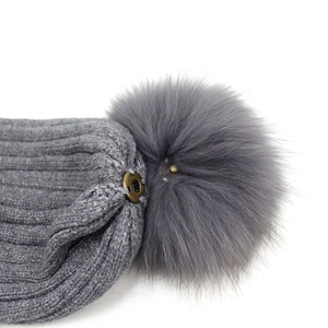 Dark grey knitted beanie with thick rib texture and large faux fur pom-pom detail