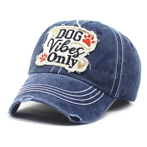 Dettaglio della texture in denim invecchiato e della toppa 'DOG Vibes Only' sul berretto