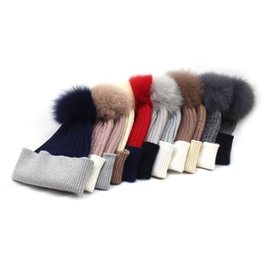 Women's warm winter knitted hats with faux fox fur pom-poms in various colors