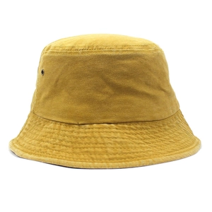 Detailed macro view of mustard yellow cotton bucket hat with ventilation eyelets and stitching