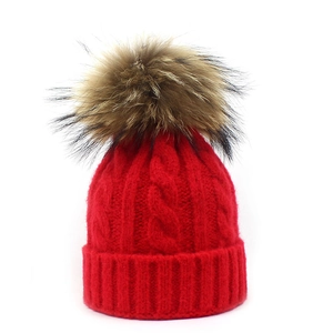 Bright red cable knit wool beanie for women and kids with a large faux fur pom-pom