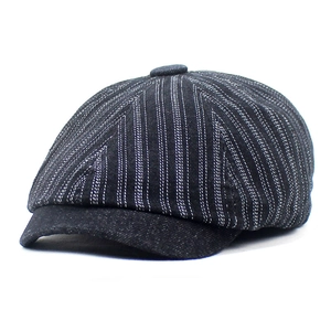 Close-up of vintage denim newsboy cap featuring white stripes and textured stitching