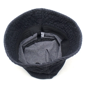 Interior detail of denim bucket hat showing 100% cotton label and black sweatband