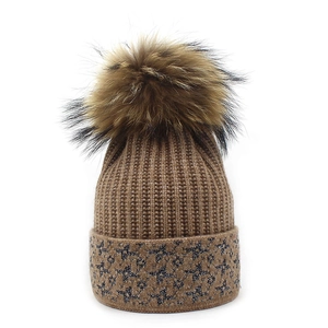 Women's knit beanie with pompom and sparkly star pattern on cuff in brown