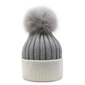 Detailed knit texture and fluffy fox fur pompom on two-tone winter beanie hat